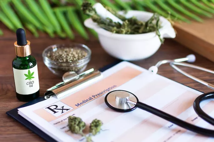CBD oil, hemp seeds, and medical cannabis items on wooden background for alternative medicine.