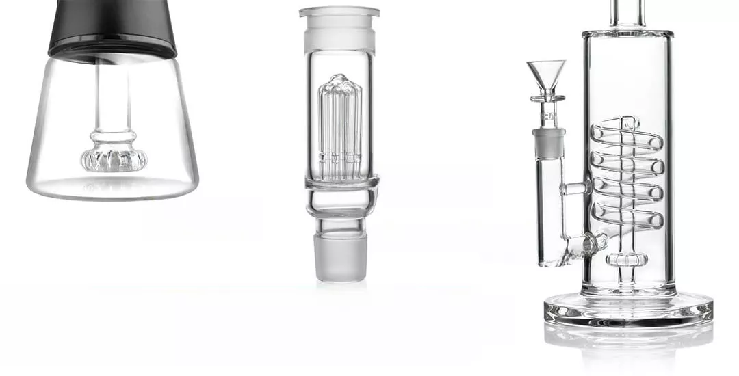 Intricate glass cannabis oil extractors and pipes on white background.