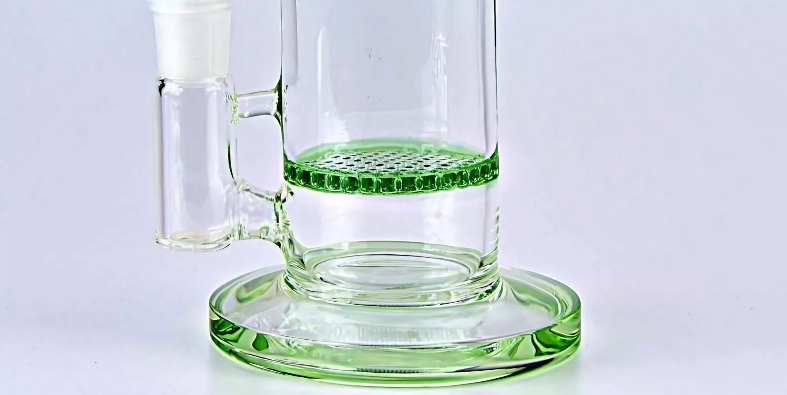 Glass cylinder diffuser with honeycomb disc and green liquid base for precise substance handling.
