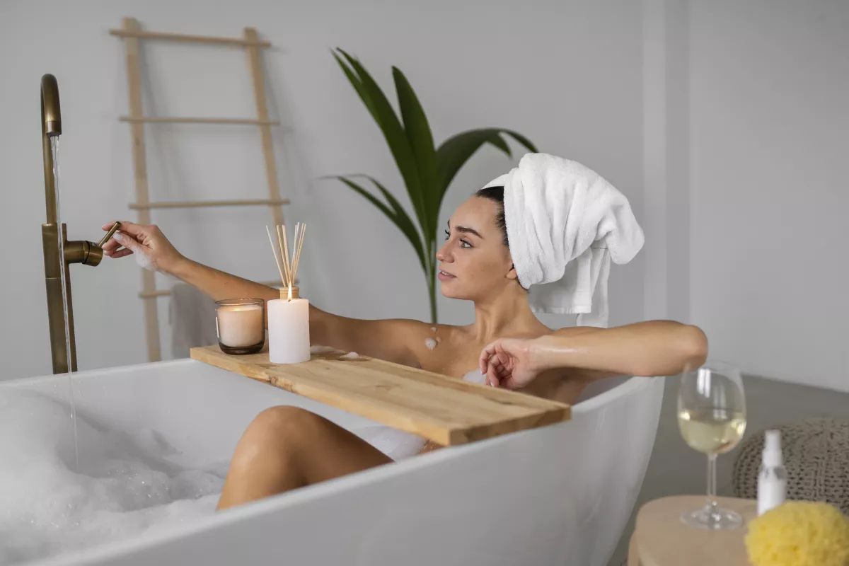 Luxurious spa bath with candle, wine, and aromatherapy for a relaxing experience.