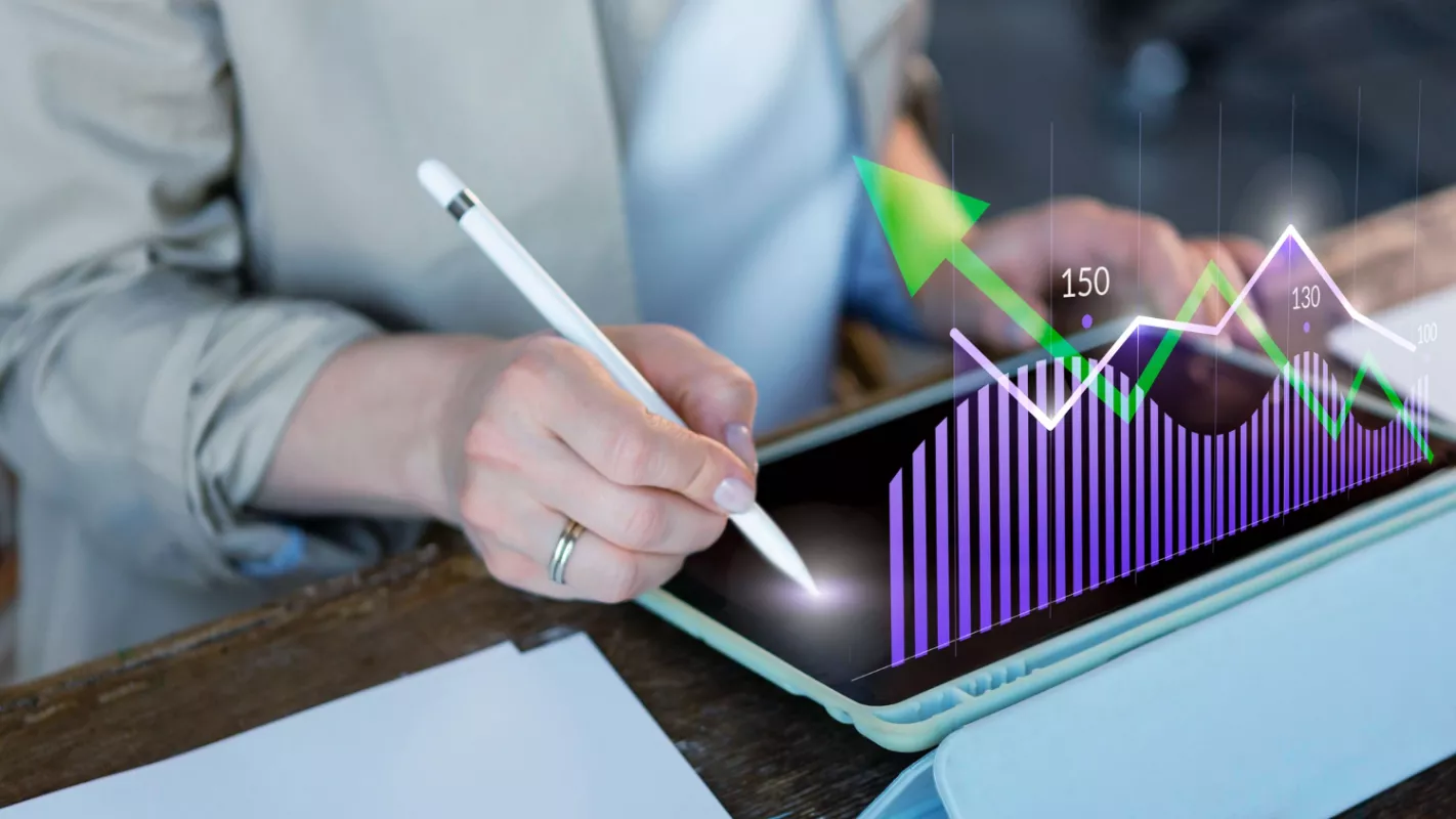 Professional analyzing data with stylus on tablet featuring augmented reality bar chart.