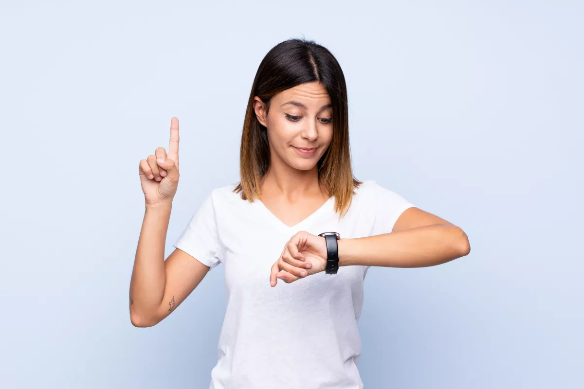 Woman glances at smartwatch, symbolizing efficient time management and technological connectivity.