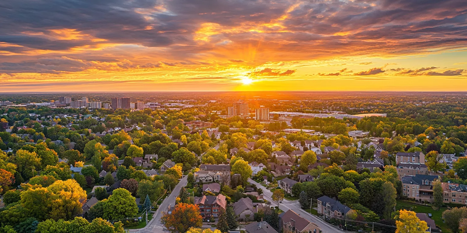 Suburban sunset with vivid sky colors, trees in bloom, and well-organized residential area.