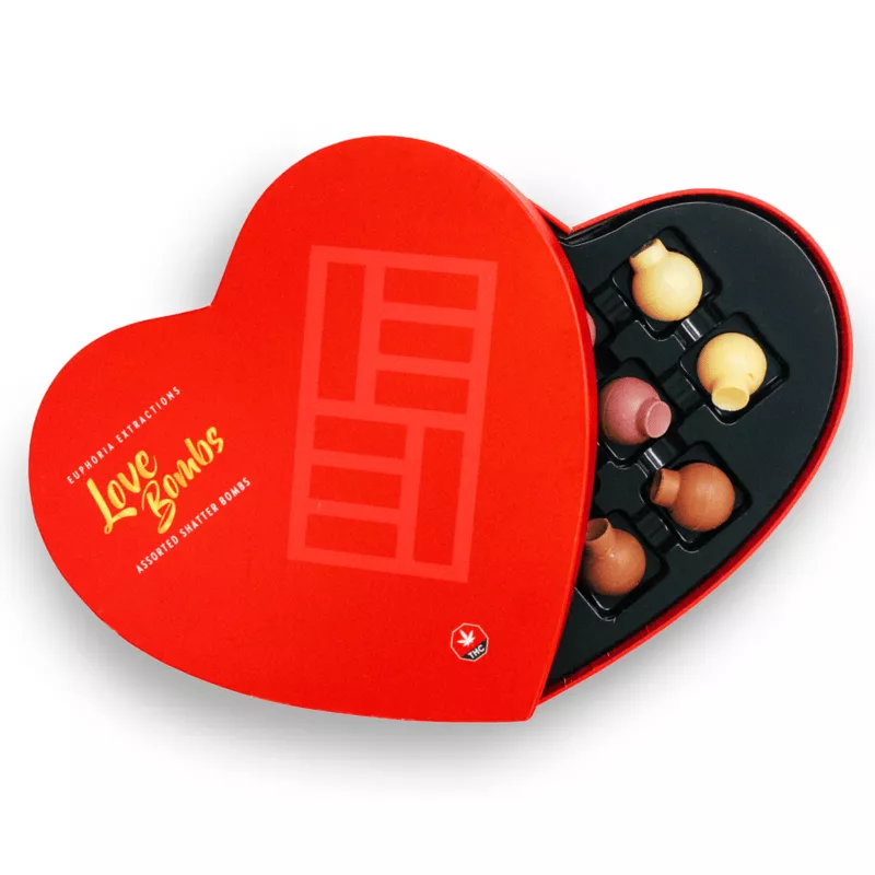 Heart-shaped box with assorted cannabis-infused chocolate Love Bombs, vibrant design, and THC symbol.