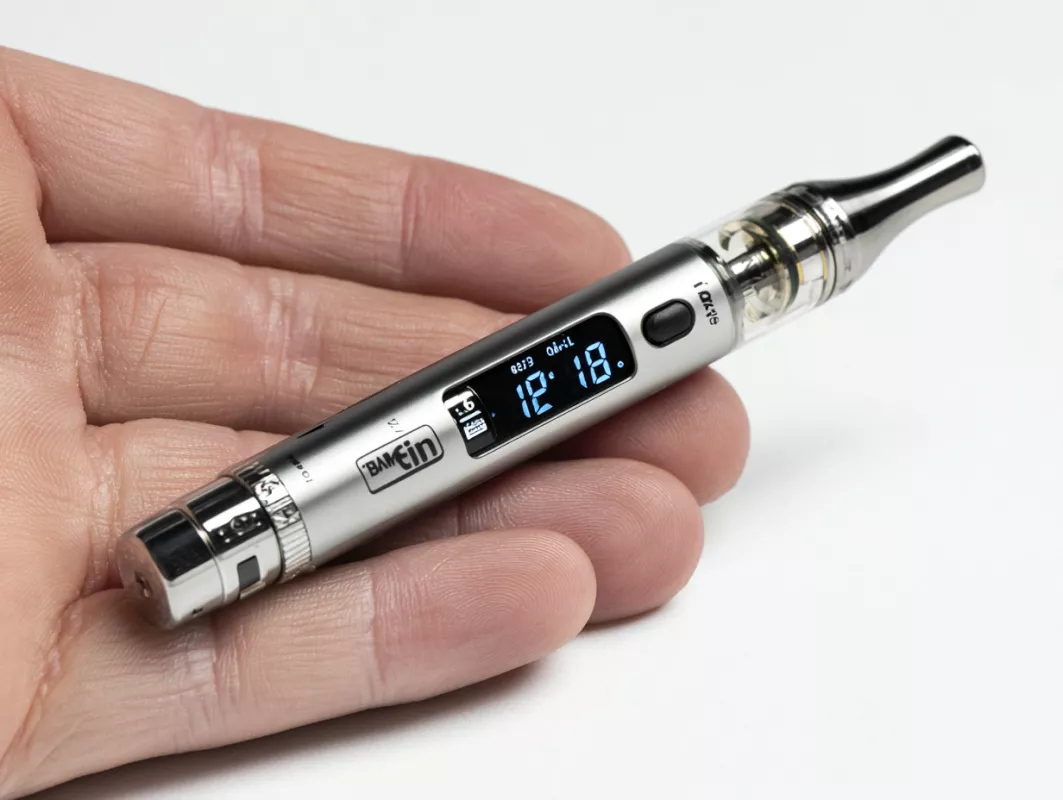 Sleek silver vaporizer with digital display, ergonomic design, and transparent chamber for e-liquid.