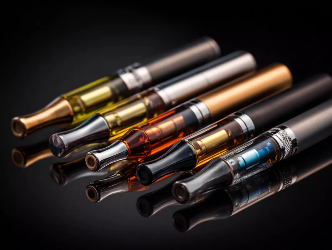 Vibrant vape pens featuring colorful e-liquid cartridges against a sleek black background.