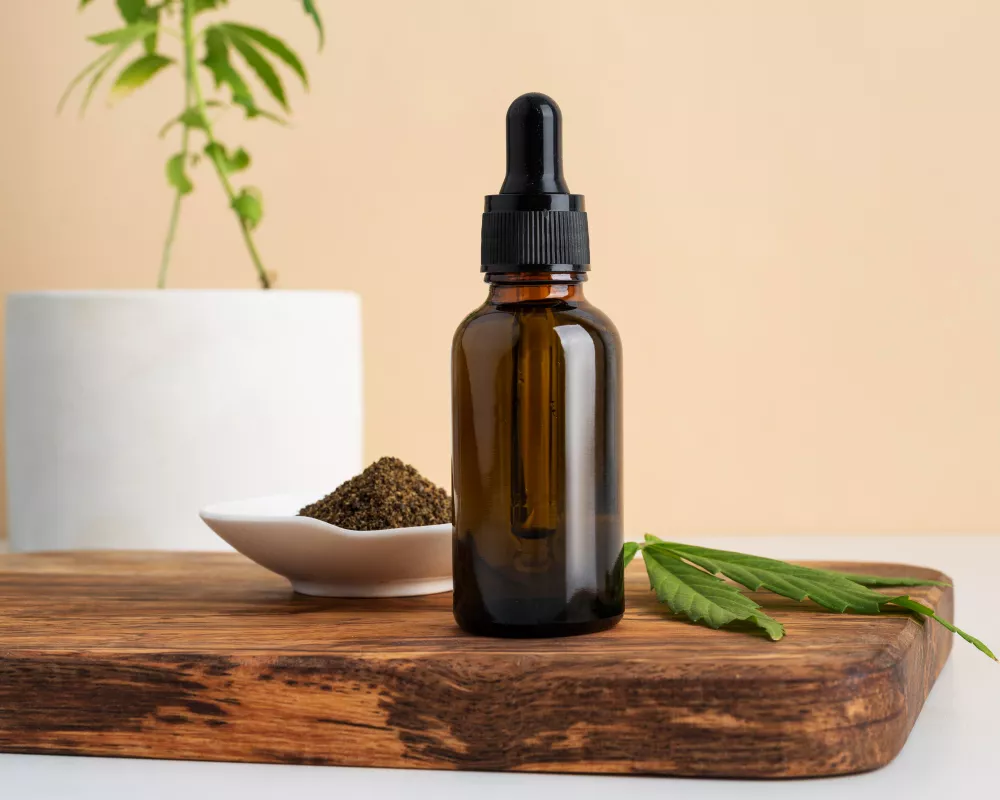 Essential oil dropper, seeds, fresh leaf on wooden board, natural wellness theme.